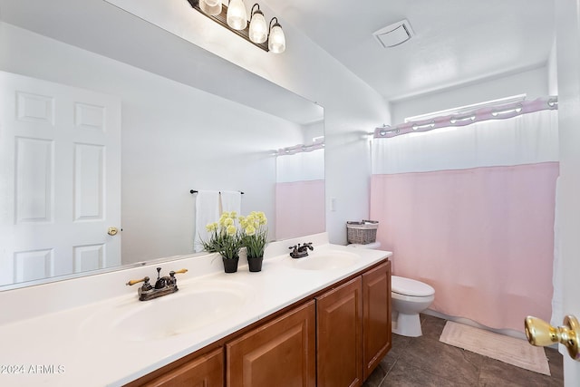 full bath with toilet, double vanity, visible vents, and a sink