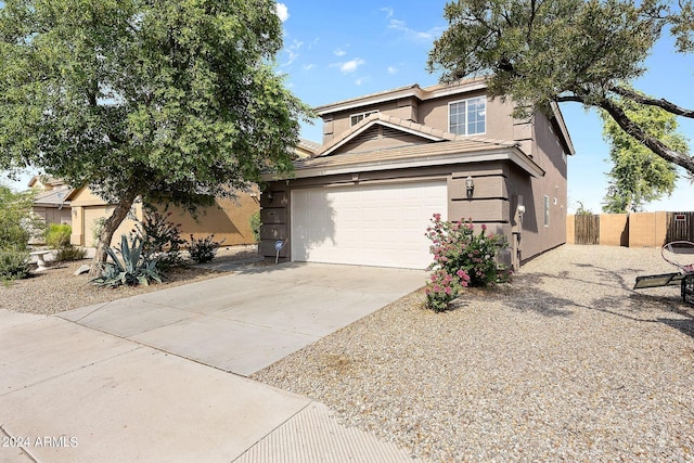 view of front facade featuring a tile roof, stucco siding, concrete driveway, fence, and a garage