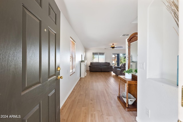 foyer featuring baseboards, visible vents, a ceiling fan, and light wood-style floors