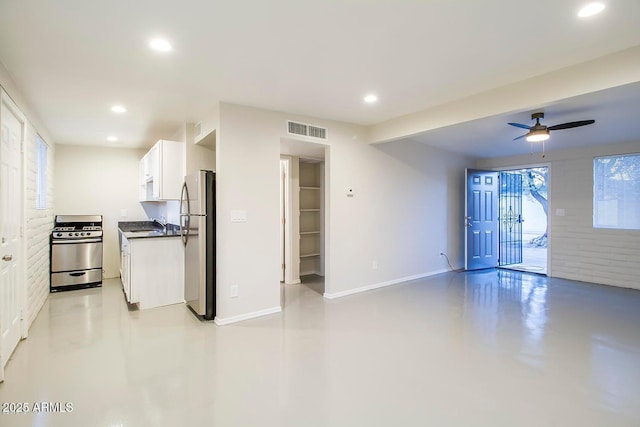 kitchen featuring ceiling fan, appliances with stainless steel finishes, white cabinets, and sink