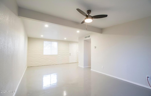 spare room featuring ceiling fan and concrete floors