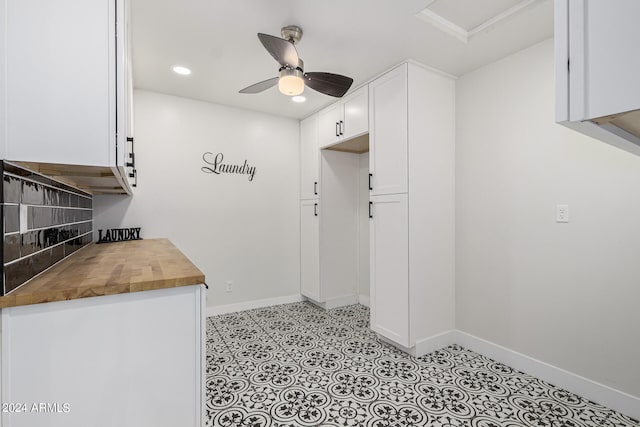 kitchen with ceiling fan, wood counters, white cabinets, and tasteful backsplash