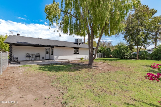 back of house featuring central AC, a lawn, and a patio area