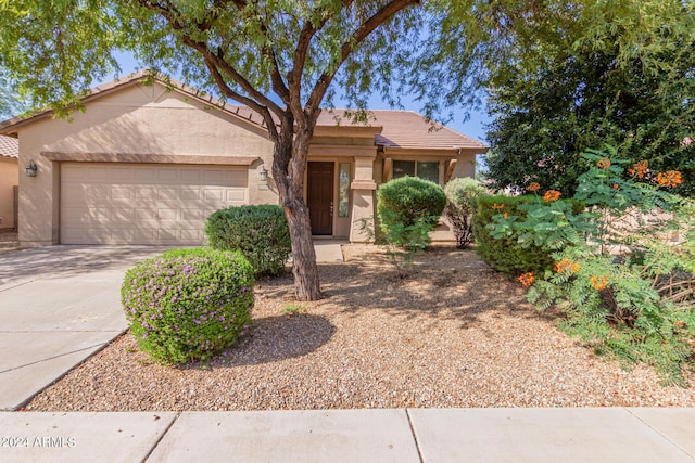 10722 W Jefferson St, Avondale, AZ 85323 - view of front of home with an attached garage, concrete driveway, a tile roof, and stucco siding