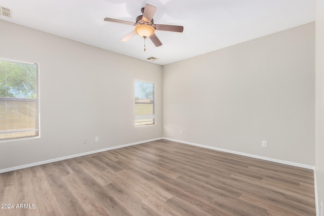 unfurnished room with ceiling fan, hardwood / wood-style flooring, and a wealth of natural light