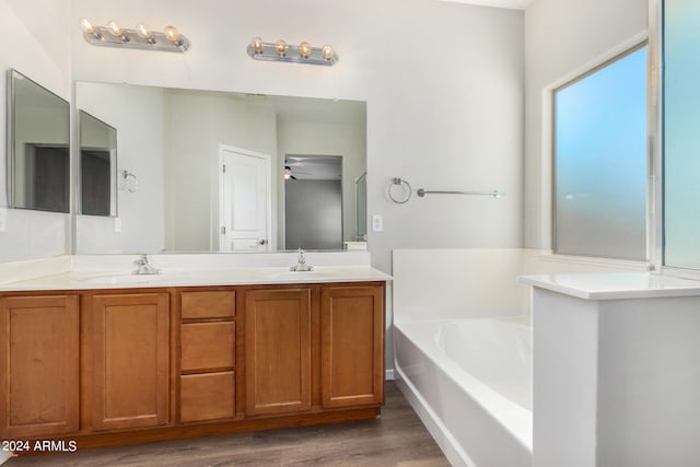 bathroom with wood-type flooring, vanity, a bathing tub, and ceiling fan