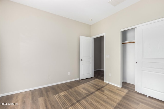 unfurnished bedroom featuring dark hardwood / wood-style flooring and a closet