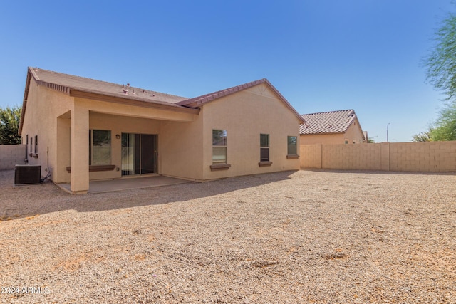 back of property with central AC unit and a patio area