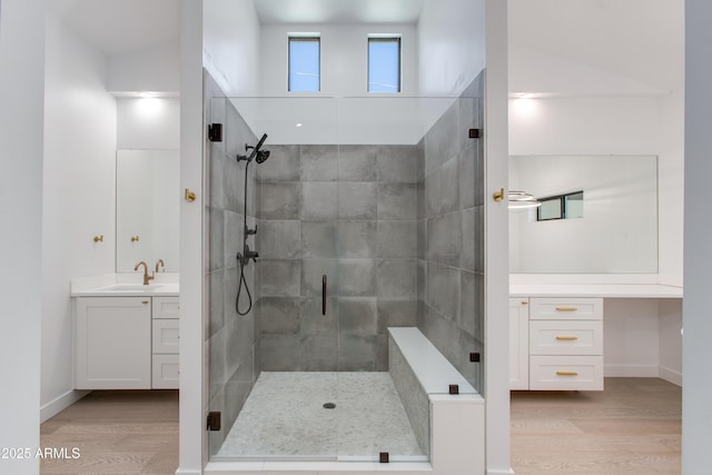 full bath with wood finished floors, vanity, and a stall shower