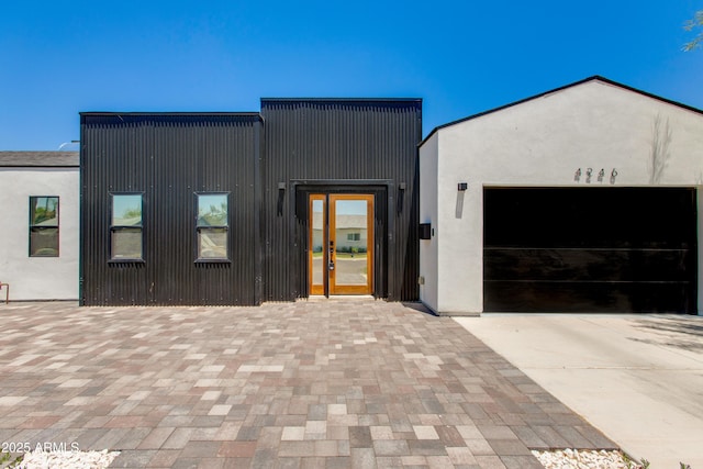 contemporary house with concrete driveway, a garage, and stucco siding