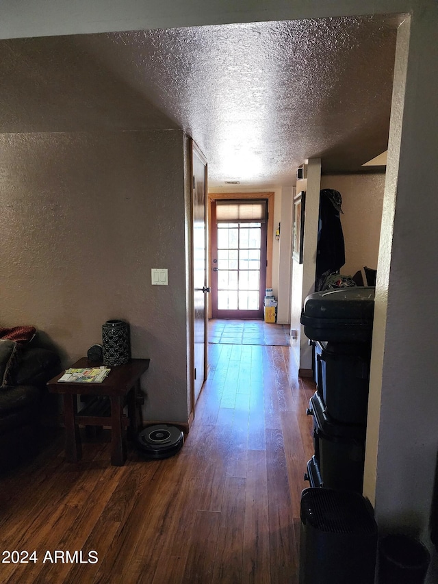 hall with dark hardwood / wood-style flooring and a textured ceiling