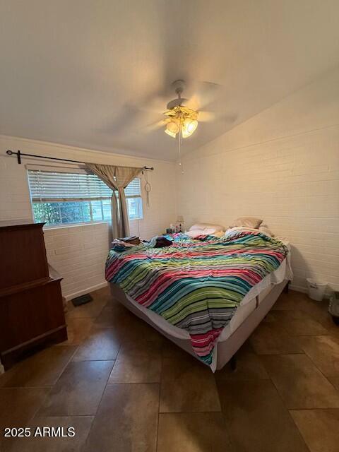 tiled bedroom featuring a ceiling fan and vaulted ceiling