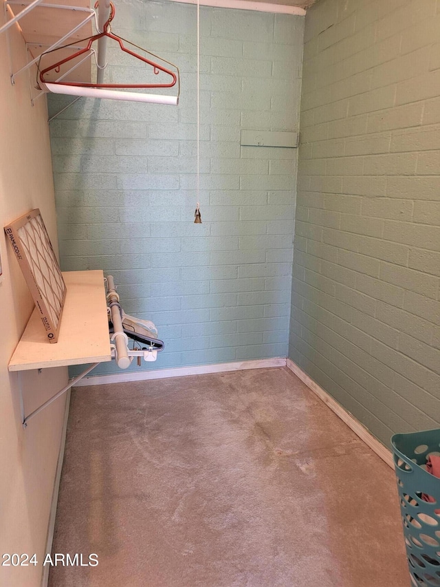 interior space featuring brick wall and concrete floors