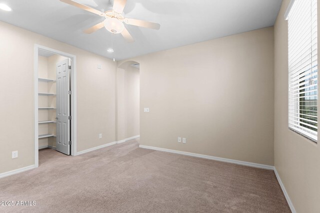 3072 E Appaloosa Rd, Gilbert, AZ 85296 - unfurnished bedroom featuring arched walkways, carpet flooring, baseboards, and a walk in closet