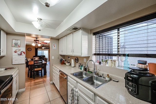 kitchen featuring white cabinets, sink, stainless steel dishwasher, ceiling fan, and light tile patterned floors