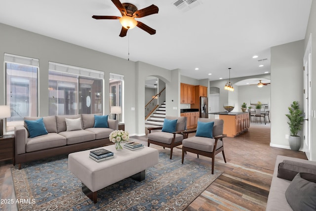 18544 E Caledonia Dr, Queen Creek, AZ 85142 - living room featuring visible vents, arched walkways, baseboards, and a ceiling fan