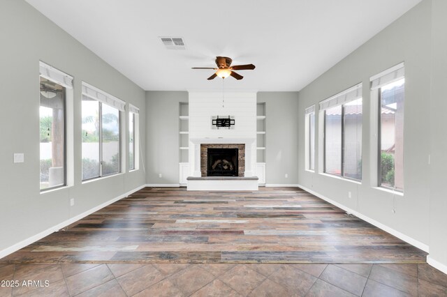 18544 E Caledonia Dr, Queen Creek, AZ 85142 - unfurnished living room with visible vents, built in shelves, baseboards, and a ceiling fan