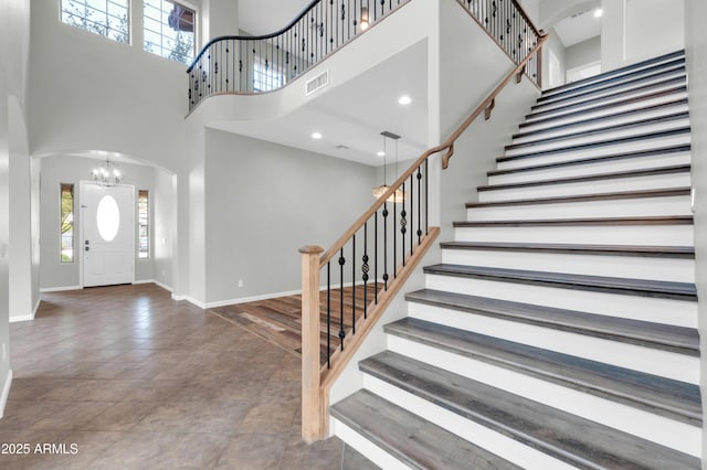 18544 E Caledonia Dr, Queen Creek, AZ 85142 - foyer entrance with visible vents, baseboards, arched walkways, stairs, and a towering ceiling