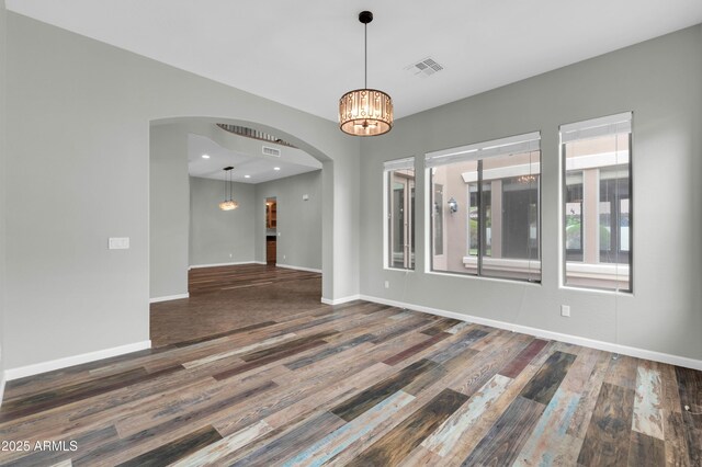 18544 E Caledonia Dr, Queen Creek, AZ 85142 - unfurnished room with a notable chandelier, wood finished floors, arched walkways, and baseboards