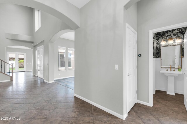 18544 E Caledonia Dr, Queen Creek, AZ 85142 - hallway featuring stairway, baseboards, a high ceiling, and arched walkways