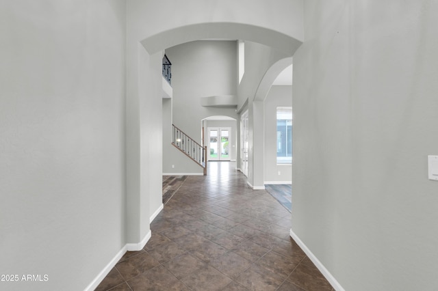 18544 E Caledonia Dr, Queen Creek, AZ 85142 - corridor with baseboards, arched walkways, a high ceiling, and stairs