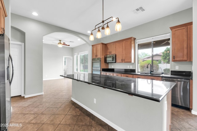 18544 E Caledonia Dr, Queen Creek, AZ 85142 - kitchen with visible vents, a sink, stainless steel appliances, arched walkways, and ceiling fan
