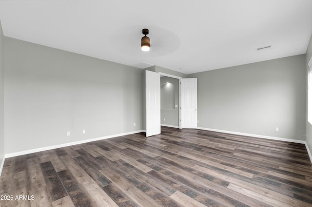 18544 E Caledonia Dr, Queen Creek, AZ 85142 - empty room with visible vents, baseboards, and dark wood finished floors