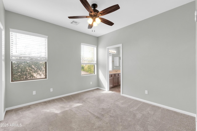 18544 E Caledonia Dr, Queen Creek, AZ 85142 - unfurnished bedroom with visible vents, a ceiling fan, ensuite bath, baseboards, and light colored carpet