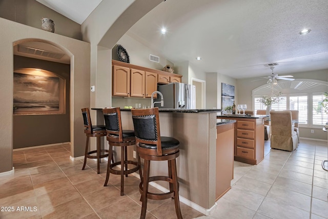 2984 N 152nd Dr, Goodyear, AZ 85395 - kitchen featuring freestanding refrigerator, a peninsula, a ceiling fan, light tile patterned floors, and recessed lighting