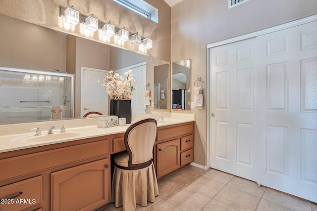 2984 N 152nd Dr, Goodyear, AZ 85395 - bathroom featuring tile patterned flooring, double vanity, a shower stall, and a towering ceiling