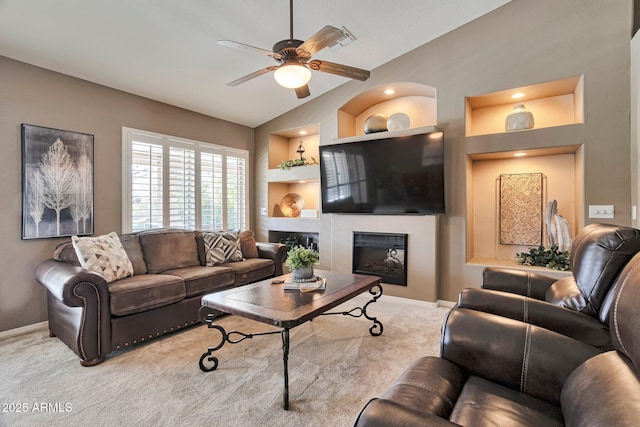 2984 N 152nd Dr, Goodyear, AZ 85395 - living area with a ceiling fan, built in shelves, light carpet, and a glass covered fireplace