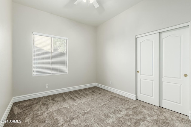 unfurnished bedroom featuring light carpet, a closet, and ceiling fan