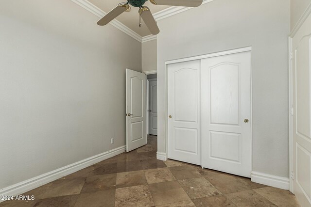 unfurnished bedroom featuring ceiling fan, a closet, and crown molding