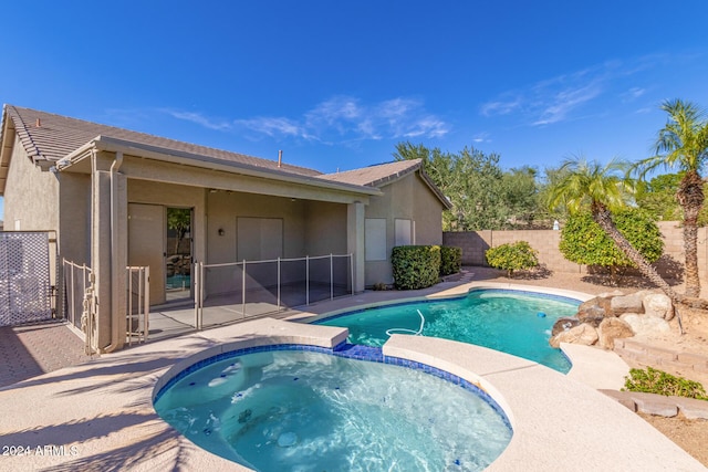 view of pool with an in ground hot tub