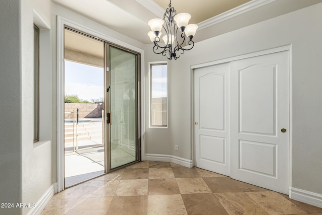 entryway featuring ornamental molding and a notable chandelier