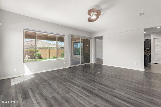 unfurnished living room with visible vents, baseboards, and dark wood finished floors