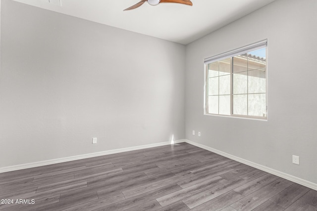 spare room with ceiling fan, baseboards, and dark wood finished floors