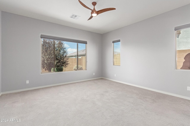 carpeted empty room featuring visible vents, baseboards, and a ceiling fan