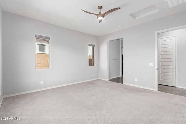 empty room featuring attic access, visible vents, baseboards, a ceiling fan, and carpet floors