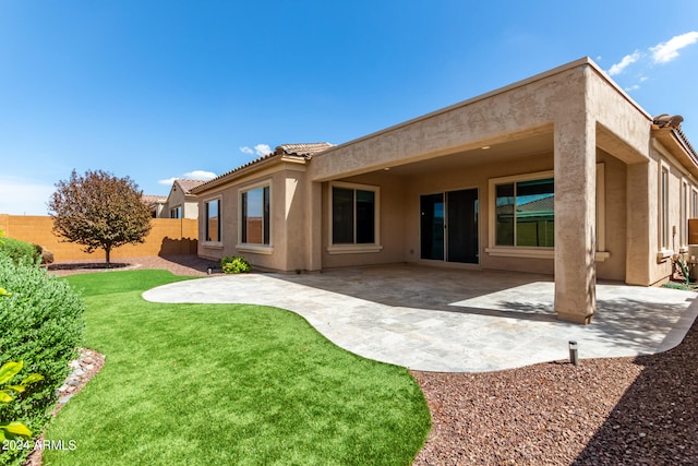 back of house with a patio area and a yard