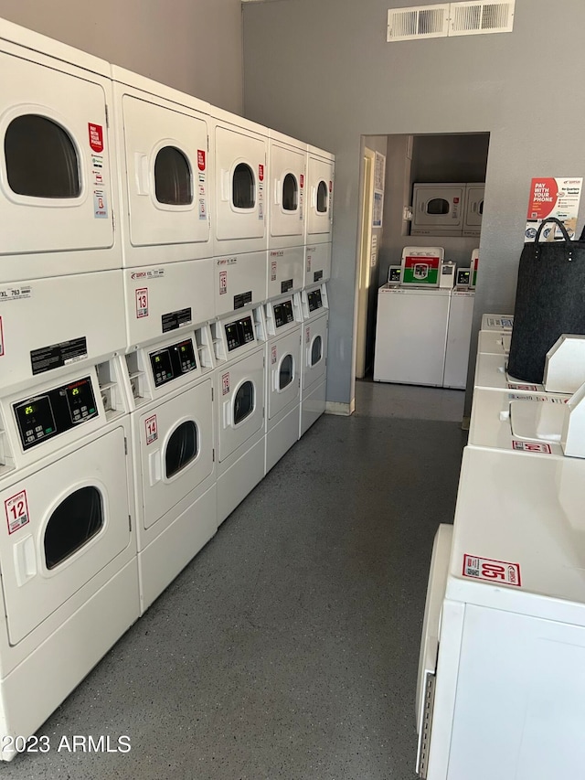 clothes washing area with washer and dryer and stacked washing maching and dryer