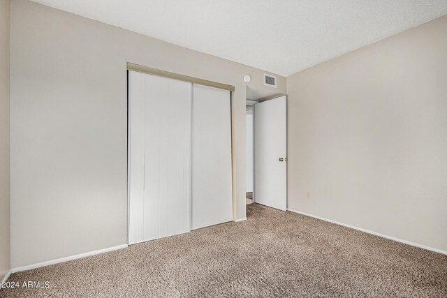 unfurnished bedroom with carpet and a closet