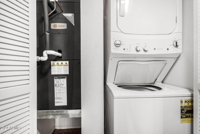 clothes washing area featuring stacked washer and clothes dryer