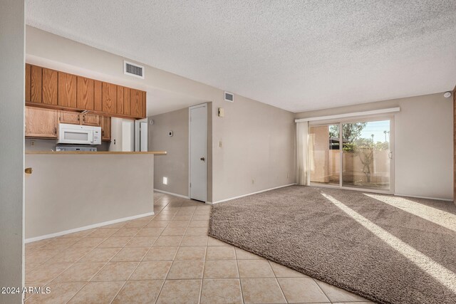 interior space with light tile patterned floors and a textured ceiling