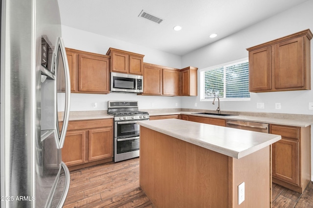 kitchen with visible vents, light countertops, wood finished floors, stainless steel appliances, and a sink