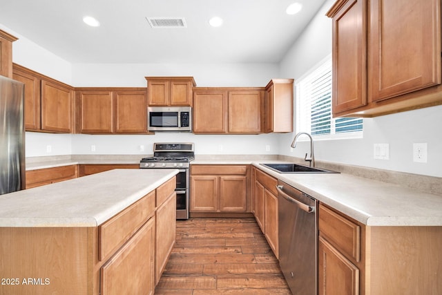 kitchen featuring visible vents, light countertops, appliances with stainless steel finishes, dark wood-style floors, and a sink