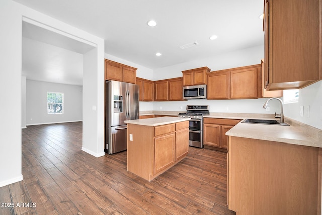 kitchen with a sink, stainless steel appliances, dark wood-type flooring, and a center island