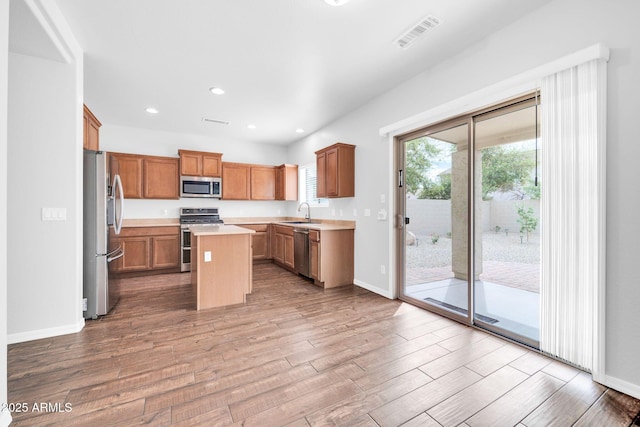 kitchen with visible vents, a center island, light countertops, appliances with stainless steel finishes, and wood finished floors