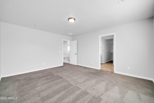 empty room featuring carpet flooring and baseboards