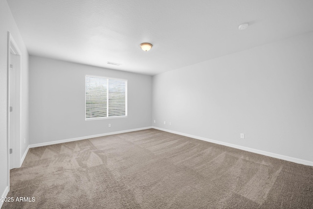 empty room with baseboards, visible vents, and carpet floors